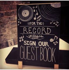 a sign that says for the record here, sign our guest book with musical notes on it