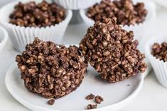 chocolate cupcakes on a white plate surrounded by other muffins