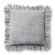 a gray and white pillow with fringes on it