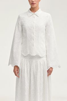 Indulge in effortless luxury with our Halima White Eyelet Top. This elegant button down top features delicate eyelet fabric and scalloped hem detailing, perfect for your next seaside escape. Embrace sophistication and style with every wear. Model is 5'7" and is wearing size XS. White Eyelet Top, White Dress Formal, Dresses Flowy, Nikkah Dress, Eyelet Fabric, Eyelet Top, Engagement Dresses, Kids Outerwear, Dress Satin