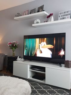 a flat screen tv sitting on top of a white entertainment center in a living room