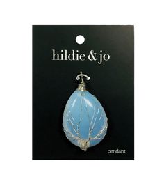 a blue glass pendant hanging from a hook on a black card with the words hildie & jo