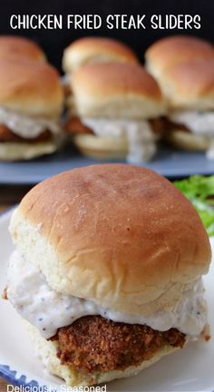 A tray in the background with sliders and one slider sitting on a plate in the foreground. Fried Cube Steak, Steak Sliders, Kinds Of Steak, Fried Steak Recipes, Slider Rolls, Country Fried Steak, Country Gravy, Hawaiian Bbq, Country Fried