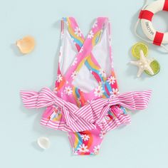 The SUNNY DAYS Bowtie Swimsuit is the perfect choice for your baby girl's summer adventures. Its cute and lively design features a lovely floral print and a charming bowtie, making her stand out at the pool or beach. Get her ready for some fun in the sun with this adorable swimsuit. Cute Swimwear For Spring Playwear, Cute Printed Swimwear For Spring, Pink Swimwear For Summer Playtime, Floral Print Swimwear For Spring Playwear, Summer Vacation Swimwear With Bow, Pink Tie-back Swimwear For Spring, Playful Multicolor Swimwear With Ruffles, Playful Multicolor Ruffled Swimwear, Summer Outfit Accessories