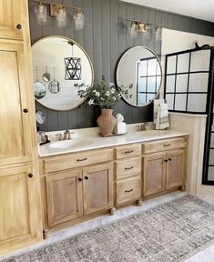 a bathroom with double sinks and mirrors on the wall, along with an area rug