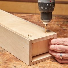 a person using a drill to cut wood