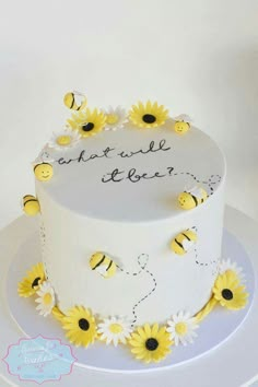 a white cake with yellow flowers and bees on it