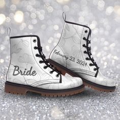 a pair of white boots with the word bride printed on them and brown soles