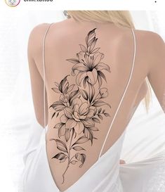 the back of a woman's body with flowers tattooed on her upper and lower back