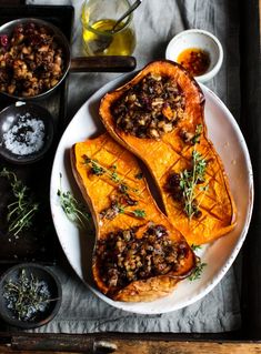 a white plate topped with sweet potatoes and other dishes on top of a wooden table