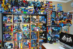 a room filled with lots of different types of toys on shelves next to a computer