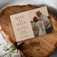 save the date card on top of a piece of wood with an image of a man and woman kissing