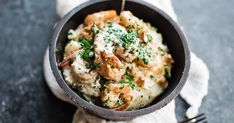 a bowl filled with mashed potatoes covered in sauce and garnished with parsley