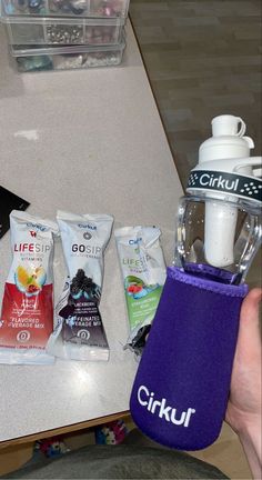 a person holding a blender and some snacks on a table