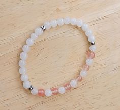 Attractive White Jade and peach pink Cherry Quartz bracelet, created using 6mm gemstone beads.  The Stainless Steel separator beads will not tarnish and provide the finishing touch. Cherry Quartz is associated with the Star Sign of Aquarius and is a symbol of beauty. White Jade is considered to have a positive power of light that is integral to the stone.   It is a spiritual stone symbolizing purity and peace.. A lovely Summer bracelet. This bracelet stretches to fit, but please specify wrist size in the options provided.  Disclaimer: It should be noted that the above information regarding the healing properties of gemstones is not medical advice.  This is for information only and should not be seen as a substitute for consulting your doctor/health care provider for advice on medical issue Wrist Mala, White Jade, Summer Bracelets, Pink Gemstones, Quartz Bracelet, Peach Pink, Summer Colors, Gemstone Bracelets, Crystal Bracelets