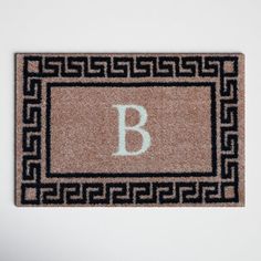 a door mat with the letter b on it and an intertwined border around it