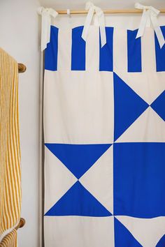 a blue and white quilt hanging on the wall