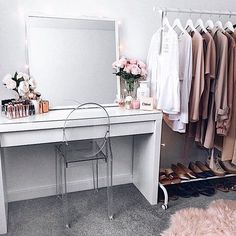 a dressing room with a vanity, mirror and shoes