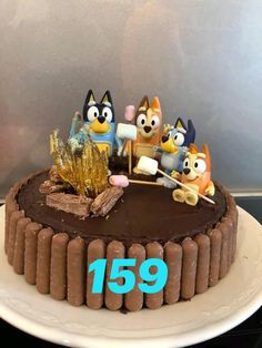 a chocolate cake with cartoon characters on top and the number fifteen in front of it