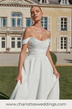 a woman in a white dress standing outside