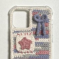 a crocheted phone case with a bow on the front and an applique in the back