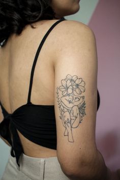 a woman with a flower tattoo on her arm and shoulder is looking at the camera