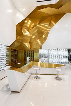 the interior of a store with gold and white accents on the walls, floors and ceiling