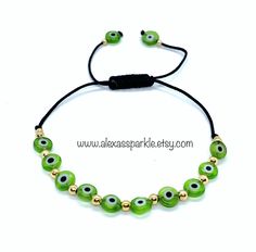 This beautifully handmade bracelet is made of flat circular shaped medium sized (6mm) glass eye beads of green color. They are made with gold colored beads and nylon thread. The bracelet is made with a woven sliding knot that allows for adjusting to different sizes. These are a great accessory for any occasion and everyday use. In many cultures it is is believed that when a person wears or carries an evil eye with them, it guards against misfortune happening in one's life. The evil eye is believ Thread Bracelets, Glass Eyes, Protection Bracelet, Sliding Knot, Eye Protection, Evil Eye Bracelet, Evil Eye, Handmade Bracelets, Green Colors