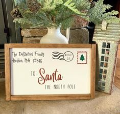 a wooden sign sitting on top of a table next to a vase filled with flowers