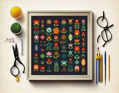 a cross stitch pattern with scissors, yarn and crochet hooks on a table