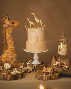 a giraffe standing next to a cake on top of a table