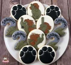 decorated cookies on a white plate with black and brown paw prints in the shape of animals