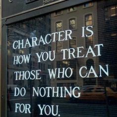 a sign on the side of a building that says character is how you treat those who can do nothing for you