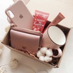 an open box filled with various items on top of a white tablecloth covered floor