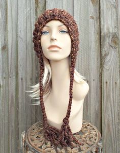 "Style: Chunky knit beanie with pom pom and braided ties, for men or women. Color: This sample hat is shown in Sequoia, a mix of browns, golds and rust. Sizes: One size fits average teen or adult head size of 20\" to 23\" (50.5 cm to 58 cm). Fiber Content: 80% acrylic, 20% Wool Characteristics: Chunky, very soft, warm and cozy. Care Instructions: Hand wash, dry flat. Every item from Pixiebell is handmade and knit or crocheted to order, unless otherwise stated in title of the item as \"ready to s Knitted Brown Yarn Bonnet, Winter Brown Yarn Bonnet, Brown Yarn Bonnet Hat, Crochet Brown Beanie For Winter, Hand Knitted Brown Yarn Hat, Brown Hand Knitted Yarn Hats, Brown Outdoor Crochet Hat, Warm Brown Yarn Hats, Warm Brown Acrylic Yarn Hat