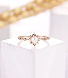 a pearl ring sitting on top of a white box