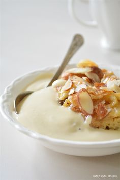 a white plate topped with food covered in sauce and toppings next to a cup