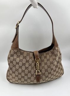 A stunning vintage Gucci Jackie bag made from the iconic GG beige canvas with brown leather trim and pale gold hardware. Inside the bag is lined with brown cotton lining and there is a zipped pocket for valuables. This bag is in good vintage condition with some slight wear to the base edges and leather parts. There is an ever so slight sticky feeling to the canvas - its only slight but need to mention. A true collectors item. Vintage Gucci Jackie, Pale Gold, Vuitton Bag, Vintage Bags, New Bag, Handbag Backpack, Gucci Jackie Bag, Vintage Gucci