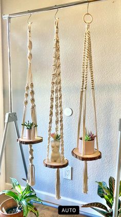 three hanging planters with plants in them