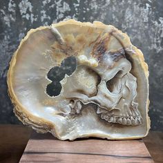 a carved skull is sitting on a wooden stand