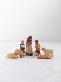 a group of wooden figurines sitting on top of a white table next to each other