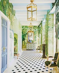 the hallway is decorated with green and white wallpaper, an ornate chandelier, and checkered flooring