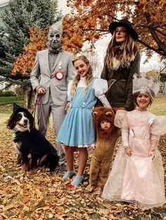 a group of people in costumes standing next to each other with a dog on a leash