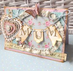 a close up of a greeting card on a table with flowers and heart shaped decorations