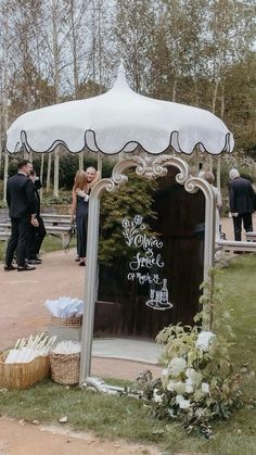 a white umbrella sitting on top of a wooden table in front of a large mirror