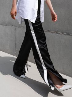 Midweight satin track trouser pants with side stripe in contract color. Straight leg with slight flare at bottom. Model is in MINUSEY S. ✔️ Free worldwide express shipping over $100✔️ Loved by 6,500+ customers✔️ Limited edition collections, maximum style⠀⠀⠀⠀⠀⠀⠀⠀⠀Stay ahead of the trend with can’t-find-anywhere-else staples. Your closet will thank you 💕* MINUSEY S = EU 34, US 2* MINUSEY M = EU 36, US 4* 100% Polyester* Dry clean* Made in Korea - Model Height: 172cm/5'7" (US2, EU34) Full Length Pants With Side Stripes, Black Full-length Pants With Side Slits, Black Wide Leg Pants With Side Slits, Black Full-length Satin Pants, Black Full Length Satin Pants, Black Satin Full-length Pants, Black Satin Wide-leg Pants, Pants With Side Stripe, Black Sweatpants Outfit