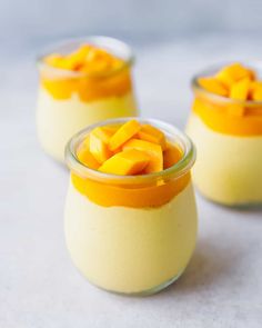 three small glasses filled with pudding and topped with mango slices