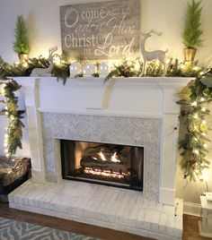 a fireplace decorated for christmas with lights and greenery on the mantel above it