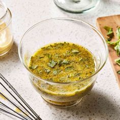 a glass bowl filled with pesto next to some chopsticks