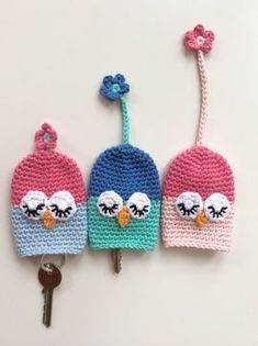 three crocheted key fobs with two owls on them and one has a flower in the middle